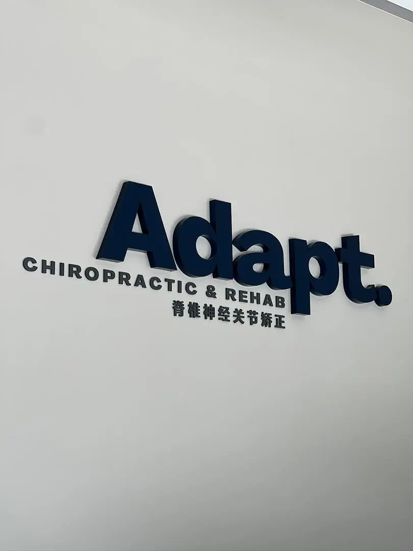 Adapt Chiropractic & Rehab logo on the clinic's reception wall